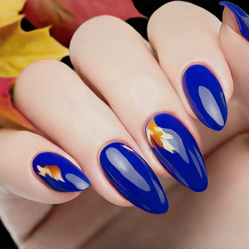 Features a royal blue, fall-theme nail with a floral style. The oval shape is accentuated by swirl techniques on a deep skin tone.
