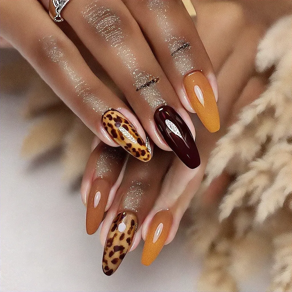 Tan almond-shaped nails featuring Thanksgiving-themed leopard print created with ombre dip powder technique. Perfect for deep skin tones.