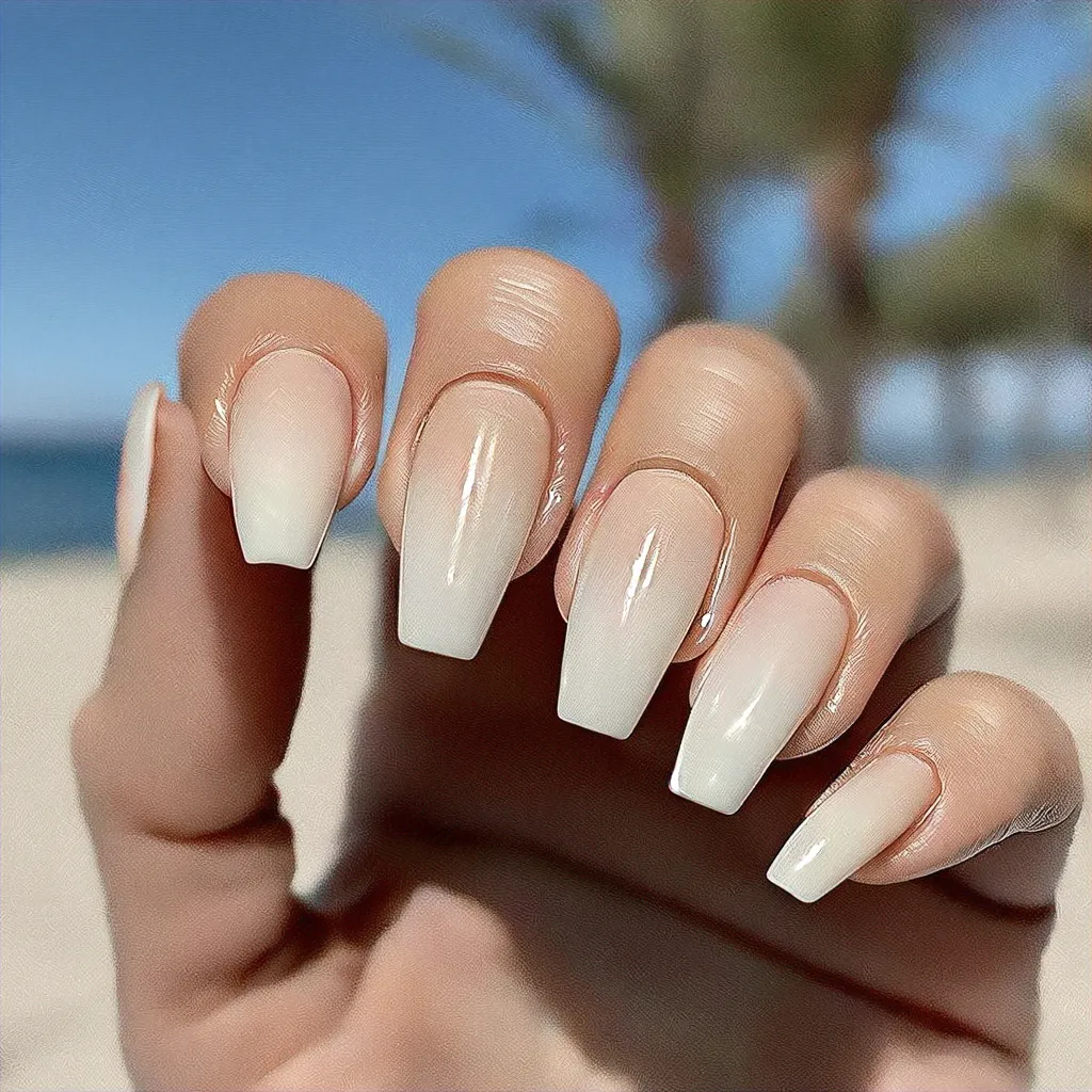 Light-toned, nude colored small coffin nails accentuated with an ombre beach theme style.