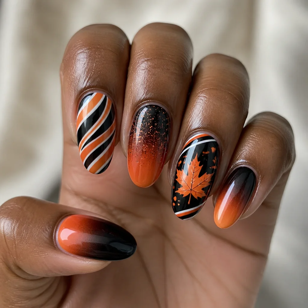 An oval-shaped, black and orange fall-themed style, executed with ombre dip powder technique, ideal for deep skin tones.