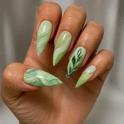 Medium-olive skin tones meet summer with a classic light green, stiletto shaped, marble technique manicure.